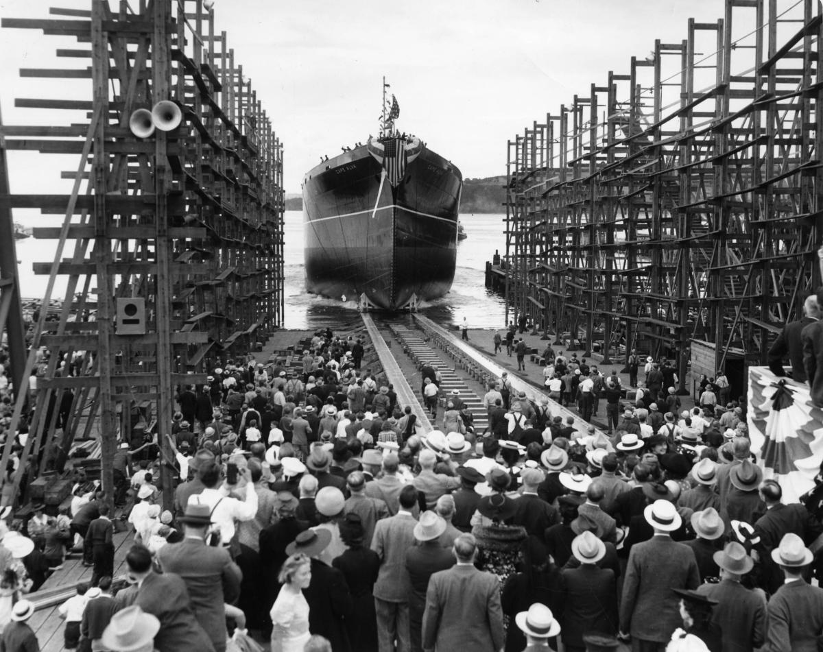 historical photo of people gathered to watch a vessel being launch 